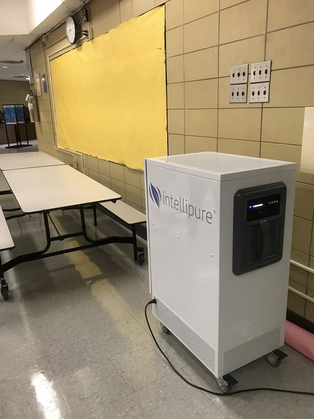 The cafeteria at Murry Bergtraum High School has a larger version of the Intellipure air purifiers being placed in city classrooms